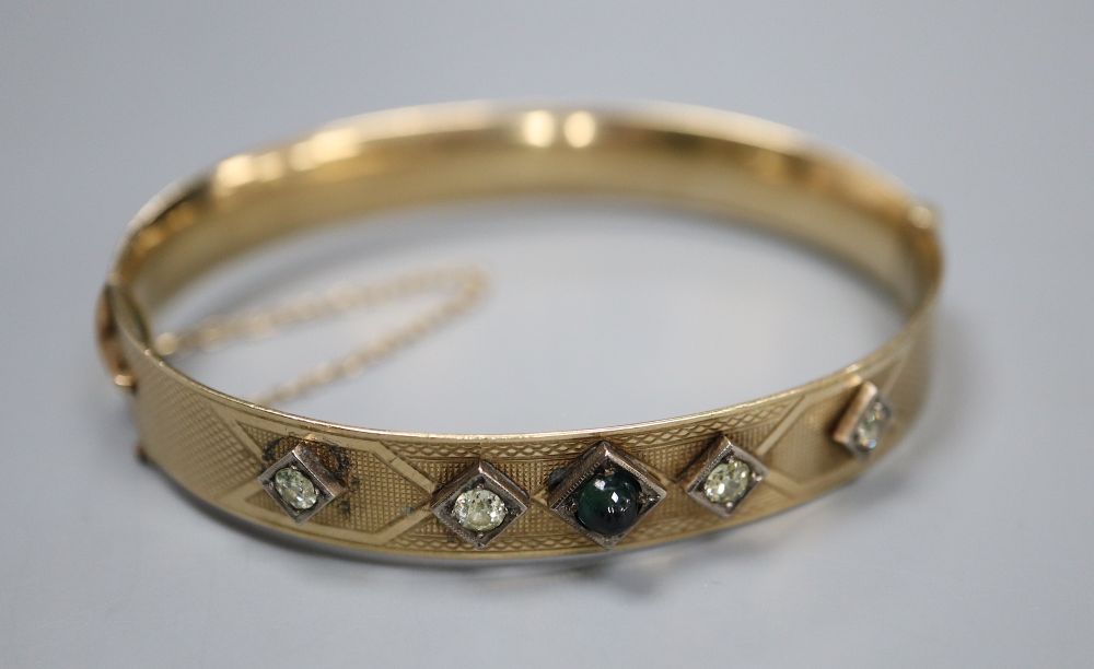 A 9ct and bronze core hinged bangle set with four diamonds and a cabochon stone.